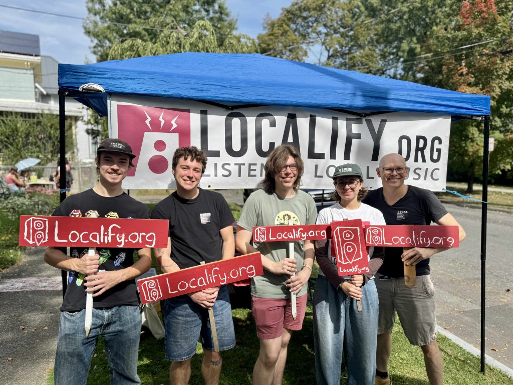 Five Localify team members holding Localify yard signs.